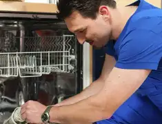 Dishwasher repair technician inspecting and servicing an open dishwasher in Naperville, IL