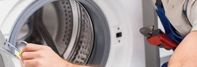 Appliance technician repairing a clothes dryer drum and internal parts in Naperville, IL