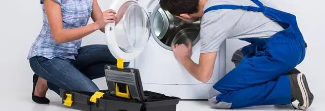 Washer repair technician inspecting a front-load washing machine with tools in Naperville, IL
