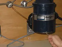 Garbage disposal repair technician tightening the mounting ring under a sink in Naperville, IL