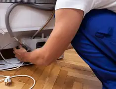 Appliance repair technician fixing refrigerator water line and connections in Naperville, IL