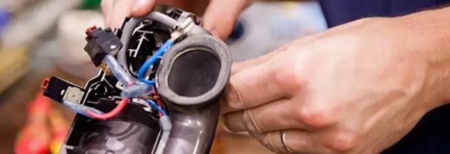 Vacuum repair technician reconnecting wiring and components in Naperville, IL