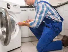 Washing machine repair technician servicing a front-load washer in Naperville, IL