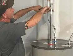 Water heater repair technician tightening supply line connections in Naperville, IL